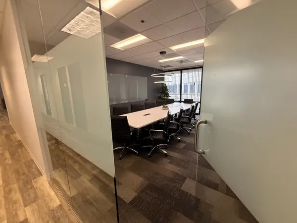The conference room seen from the corridor through its full height glass wall.