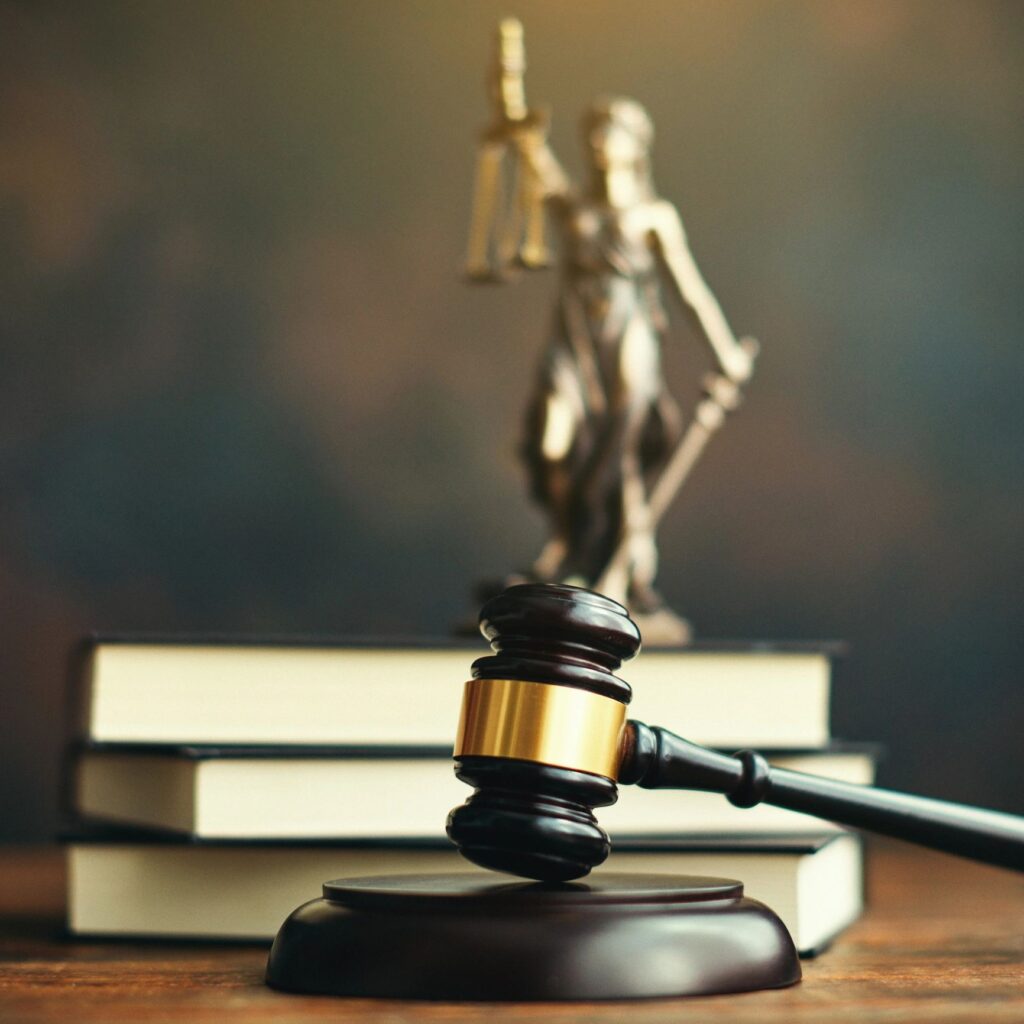 Gavel on desk with law books and Lady Justice