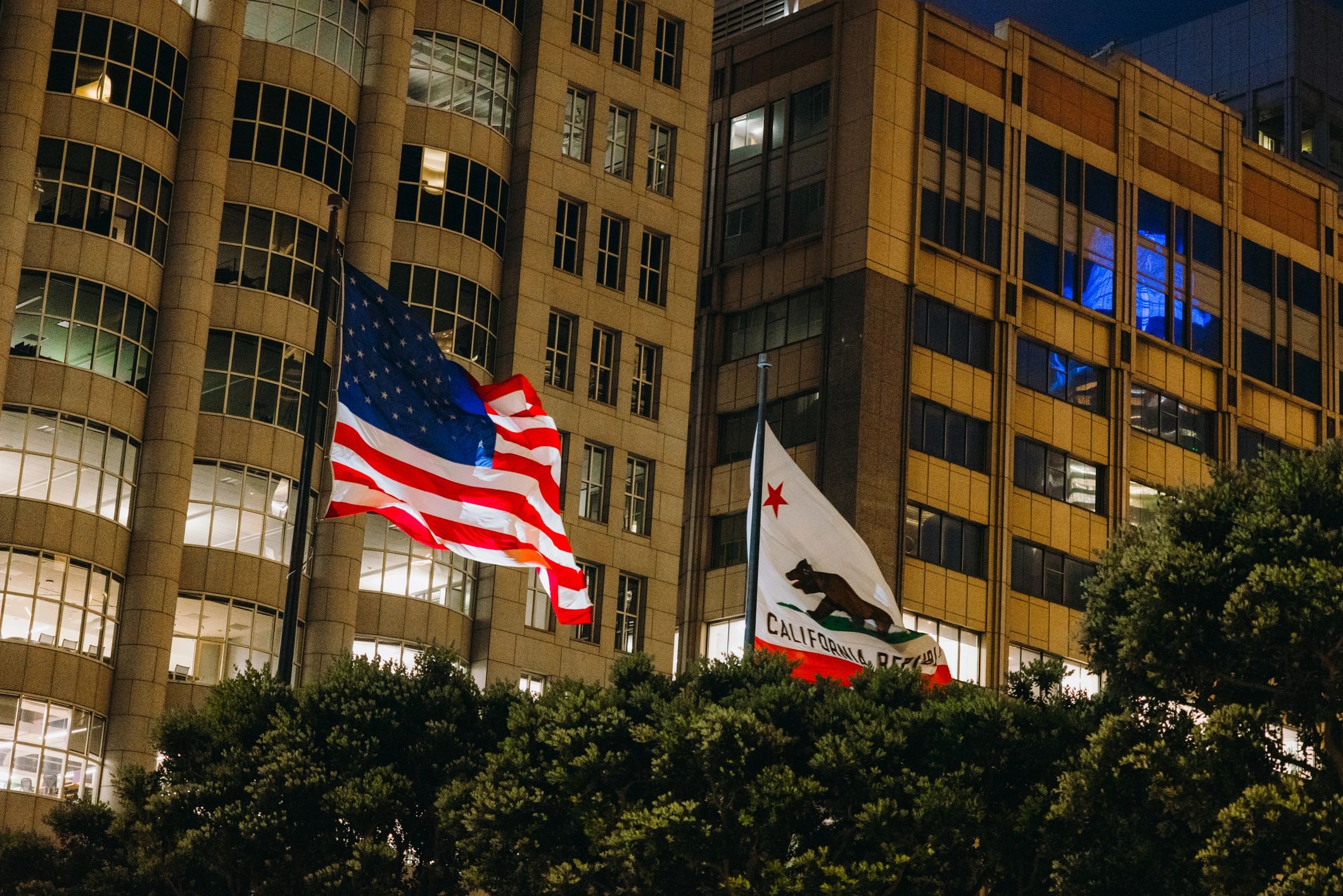 American and California Flags Waving in Citrus of San Francisco City During Night Time