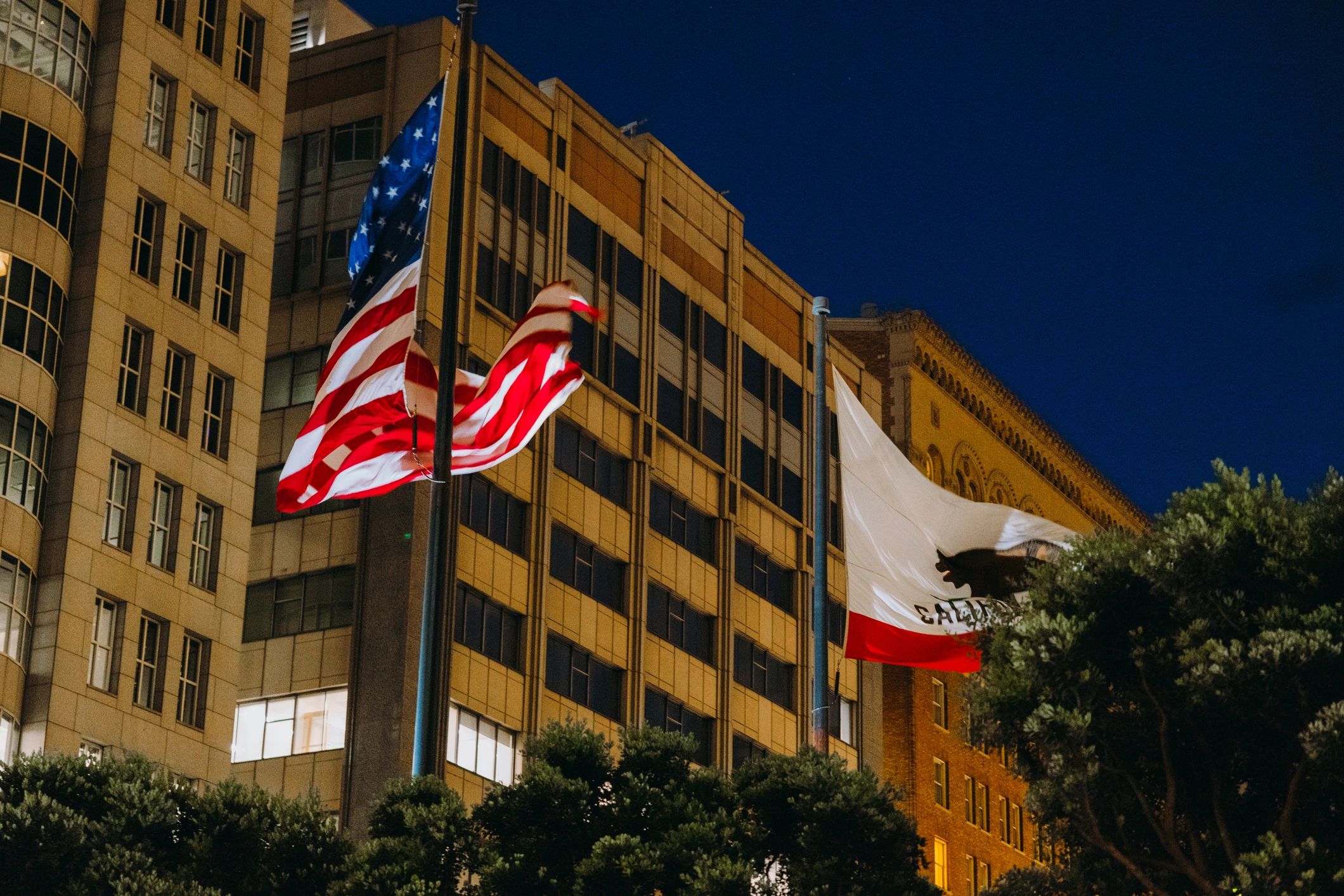 American and California Flags Waving in Citrus of San Francisco City During Night Time