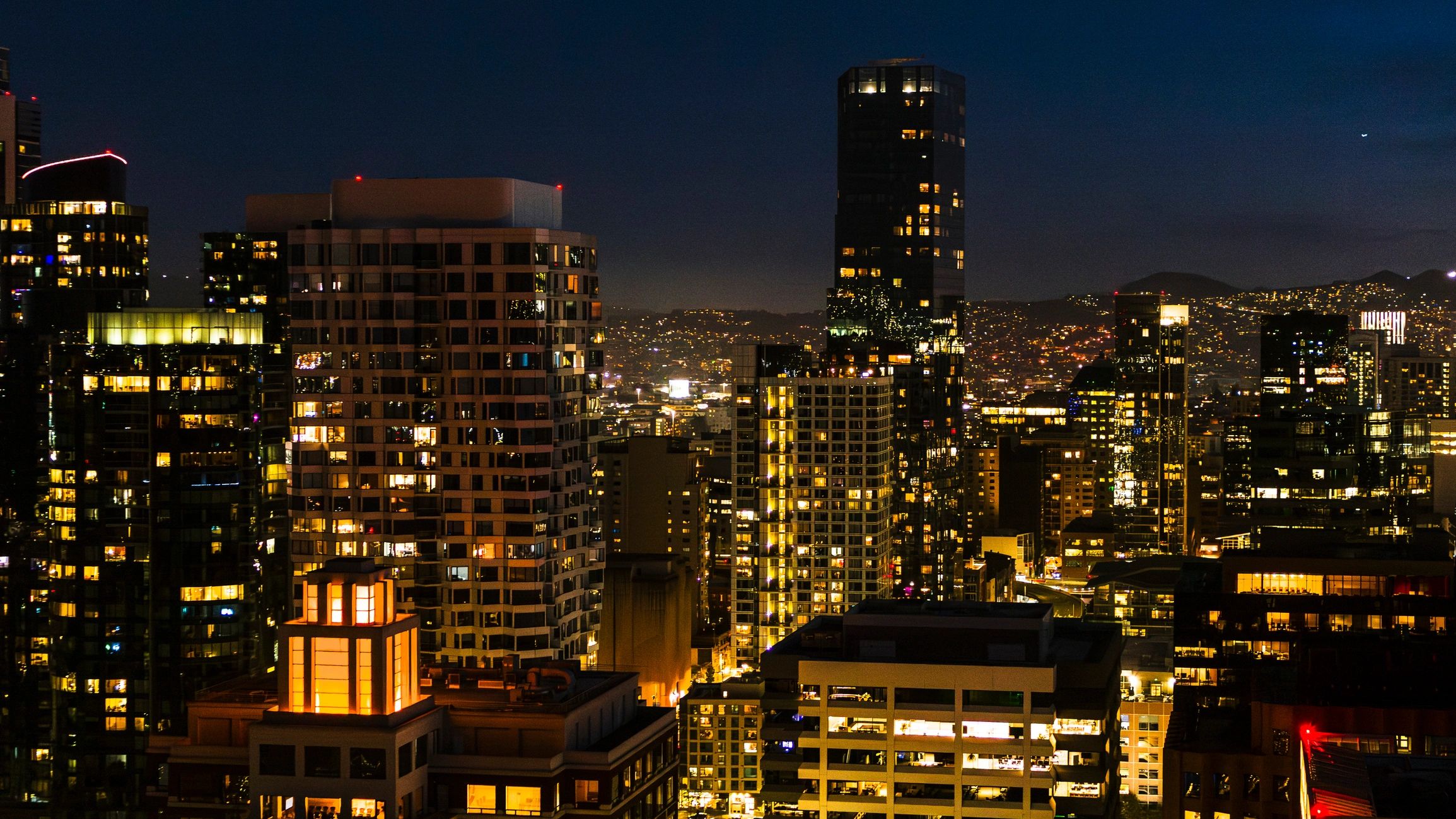 Glowing towers at night. Business district of San Francisco, California with illuminated skyscrapers.